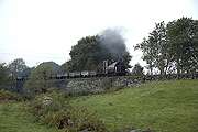 ‘Palmerston’ hustles a rake of slate waggons along Gwyndy Bank.       (15/10/2005)