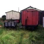 An ex-WD bogie open (formerly at Nocton?) and a bogie ambulance van stand in the overgrown yard at Humberstone North Sea Lane   (24/08/1978)