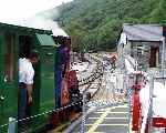 Elidir runs across the level crossing and in to the loop at Gilfach Ddu, heading for Penllyn. (06/08/2003)