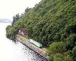 Thomas Bach heads out alongside the lake with a train for Penllyn. (06/08/2003)