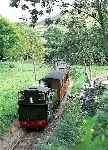 Rebuilt Andrew Barclay No 7 ‘Tom Rolt’ rolls down towards Rhydyronen station past Tynllwyn farm.   (29/09/2003)